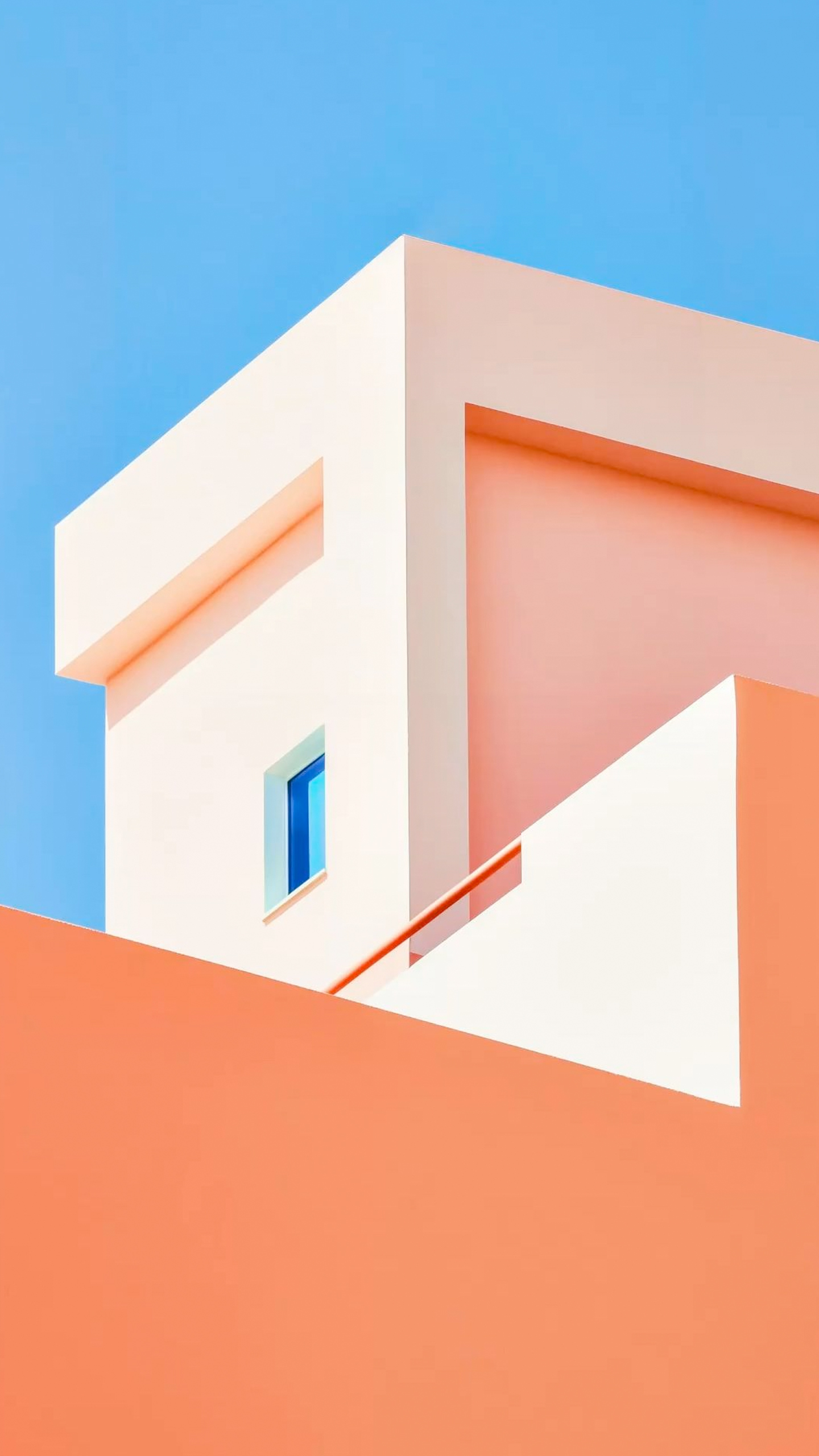 A modern building with a blue window and peach-colored walls.
