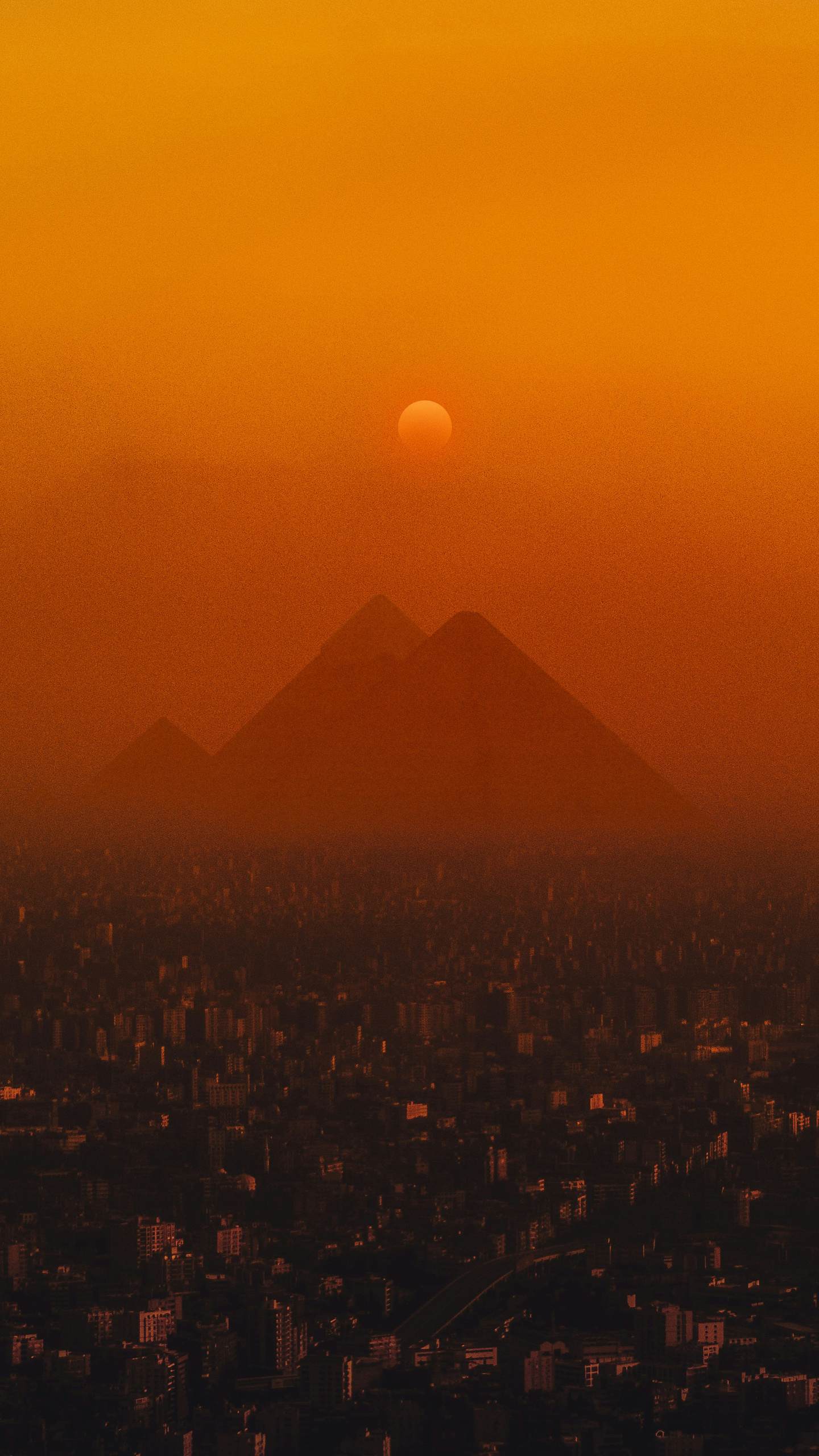 Sunlight filters through the peaks of distant mountains, casting a warm glow on the landscape.