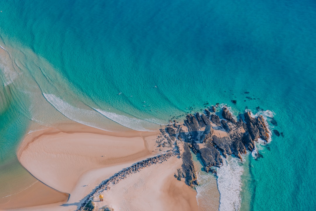 A serene beach scene unfolds, with gentle waves lapping against the shore.