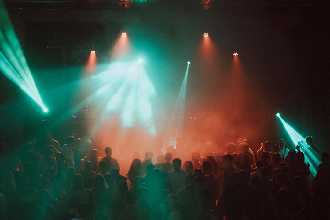 A crowd of people surrounded by bright green and red lights.