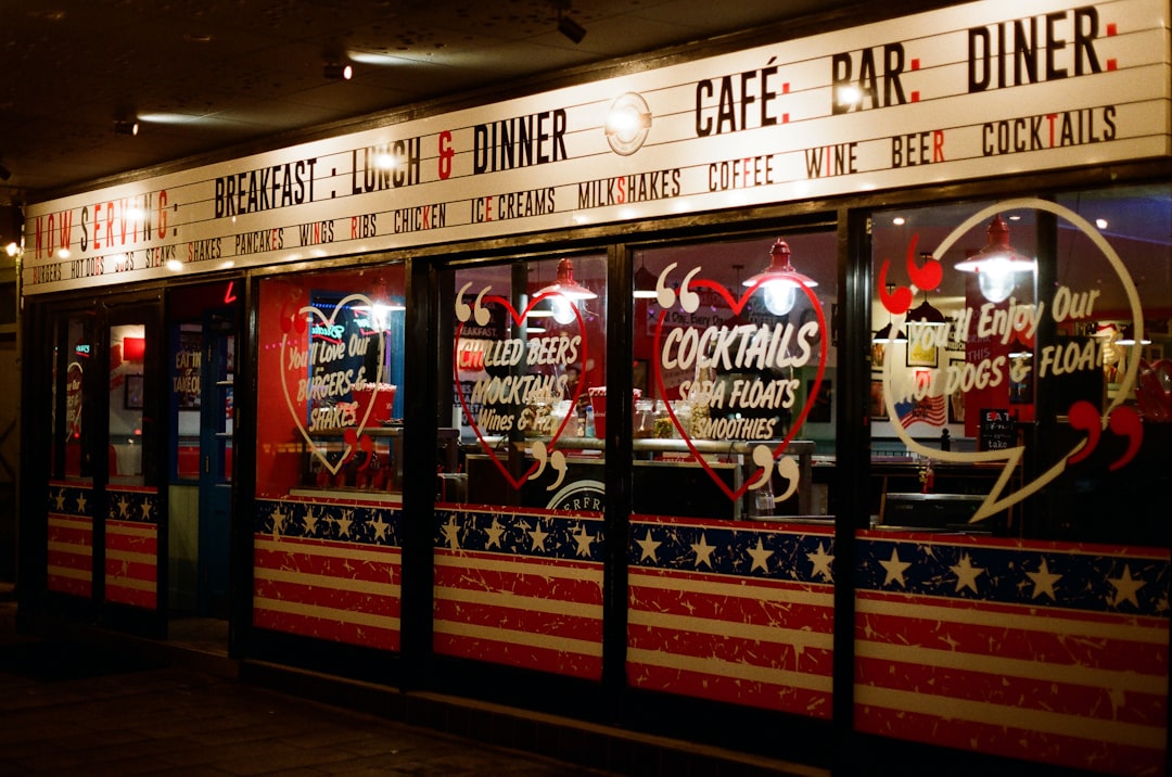 A diner with patriotic decor and a menu board, featuring a sign with the words "Cafe", "Bar", and "Diner" in red and black letters.