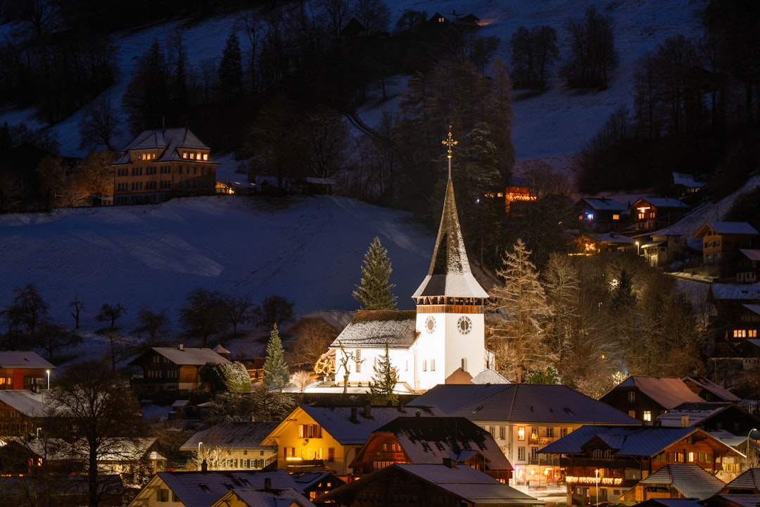 Snowy mountains in the distance, with a church and houses in the foreground.