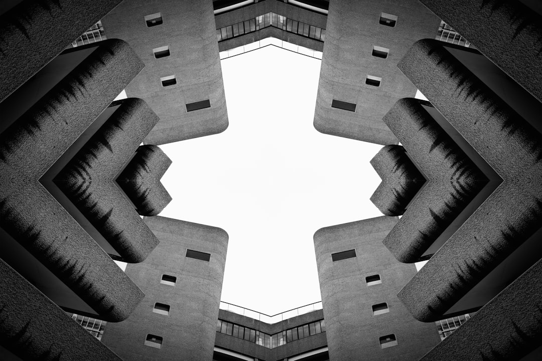 A symmetrical composition of concrete structures, reminiscent of a kaleidoscope, with a central white void and dark gray walls.