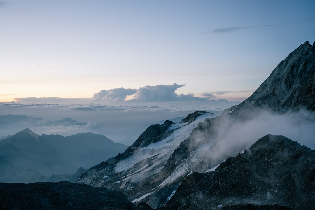 Snow-capped mountains stand tall, shrouded in mist.