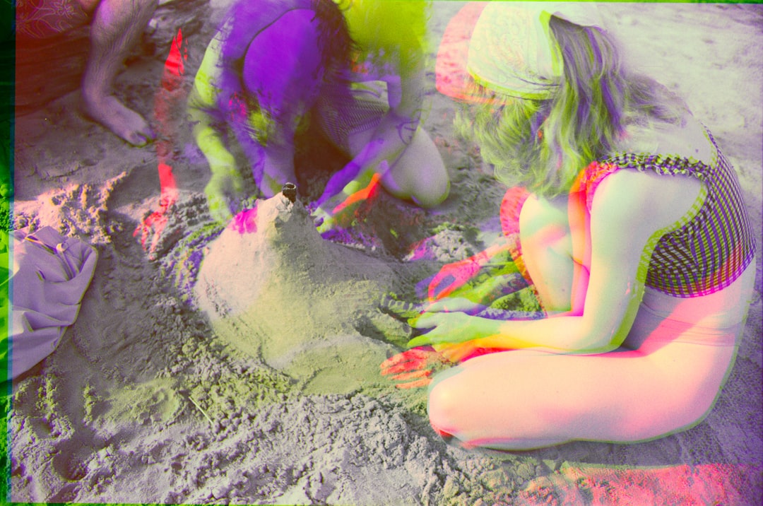 A woman in a swimsuit is building a sandcastle.