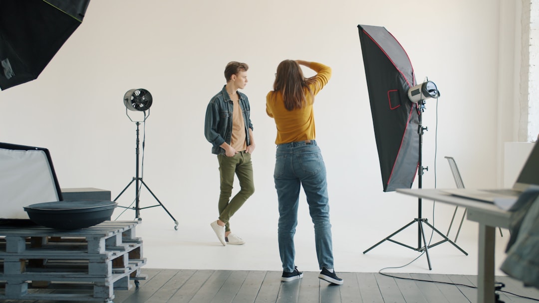 A photographer takes a photo of a man in a studio setting.