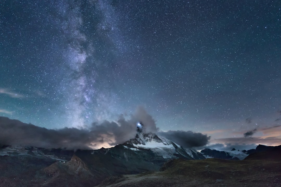 A majestic mountain range stands tall under the starry night sky.