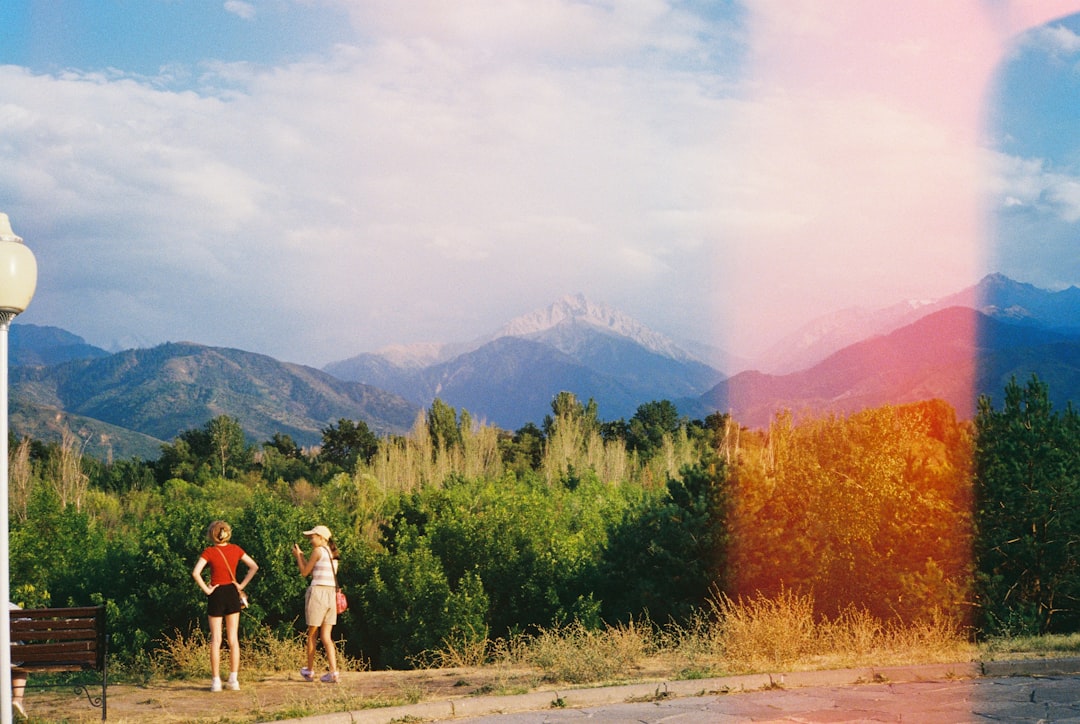 Snow-capped mountains stand out against a backdrop of lush greenery.
