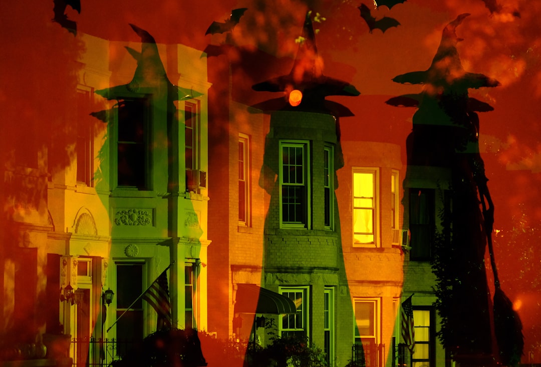 Witches' hats and bats adorn the rooftops of a row of old houses.