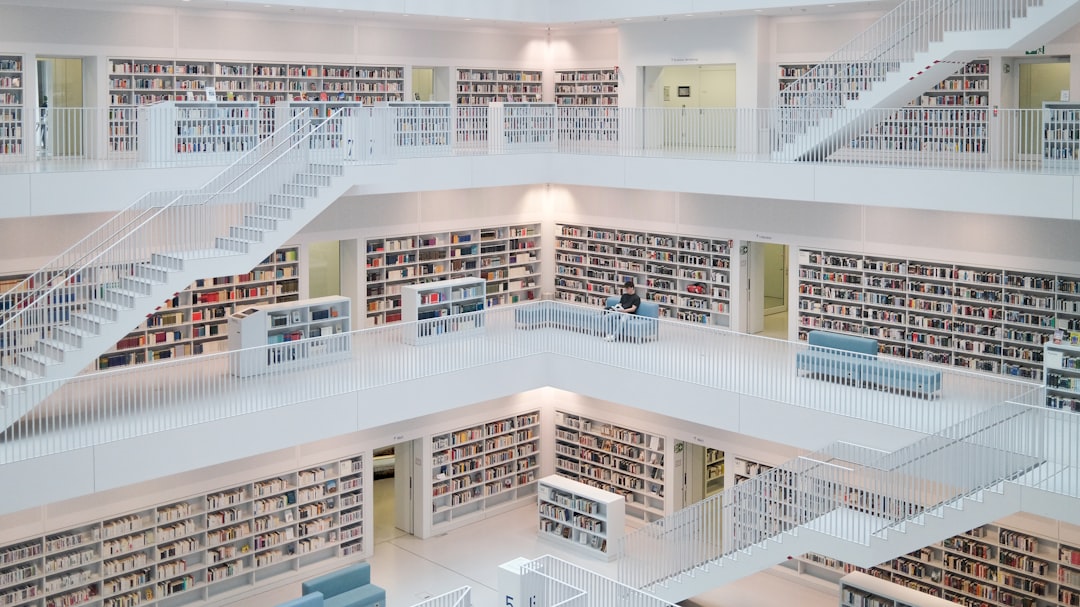 A white library with multiple levels of books and stairs is visible.