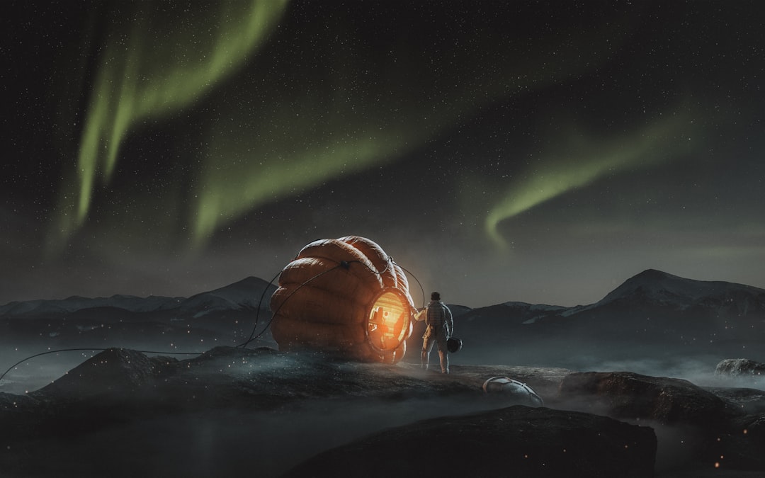 A large orange balloon-like object glows warmly on the ground, illuminated by a bright light emanating from within.