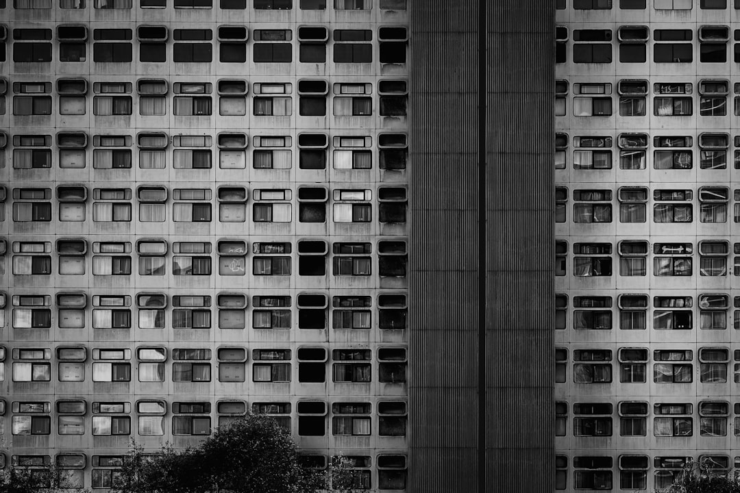 A towering building stands, its facade a grid of windows and balconies.