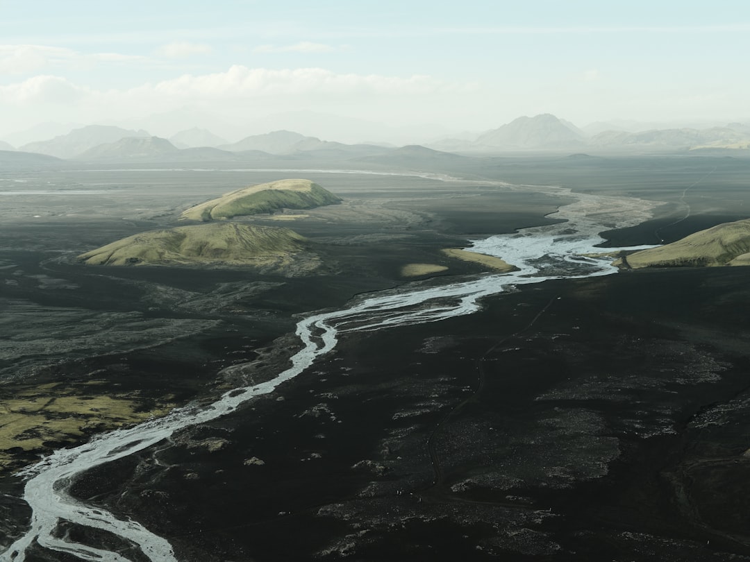 Misty mountains and a winding river create a serene landscape.