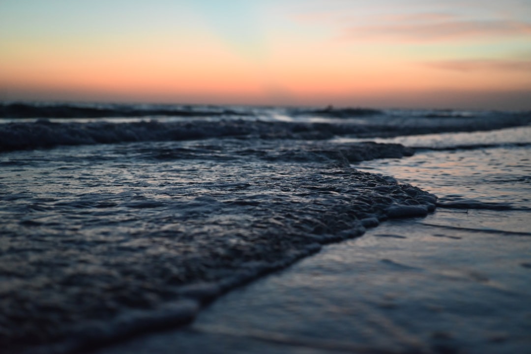 Sunset casts a warm glow on the ocean's waves.