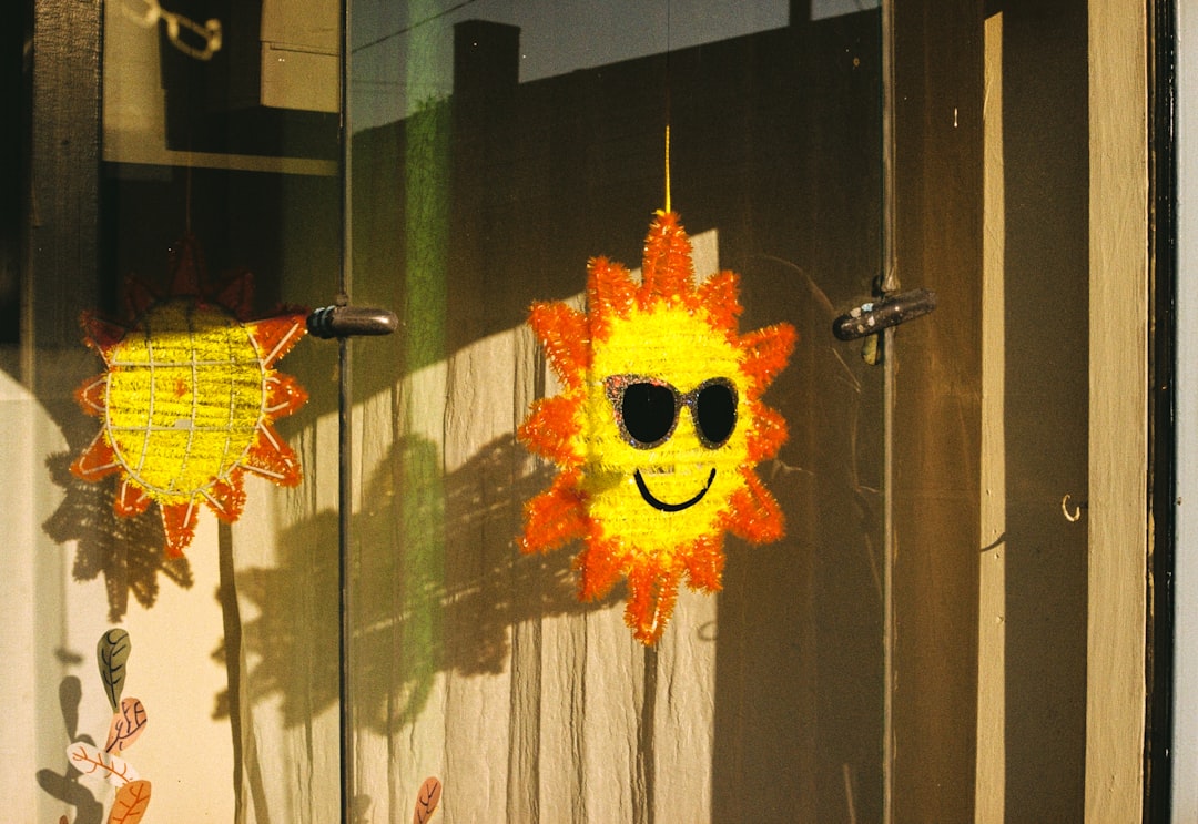 A sun-shaped decoration adorns a door, its bright yellow hue and orange edges adding a pop of color.