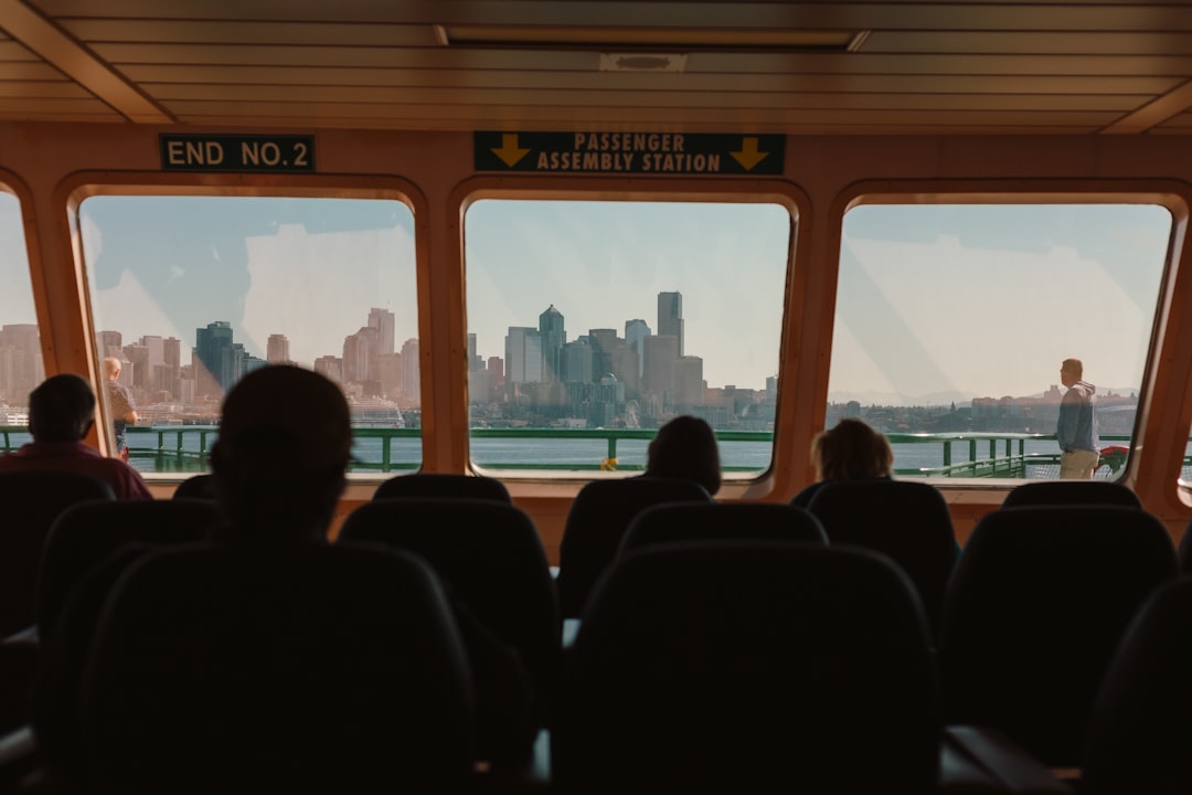 Passengers on a ferry, gazing out at a city skyline and water.
