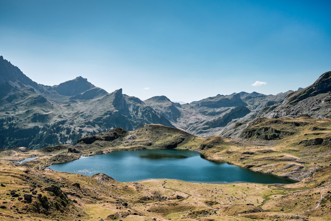 A serene blue lake nestled among rugged, rocky mountains under a clear sky.