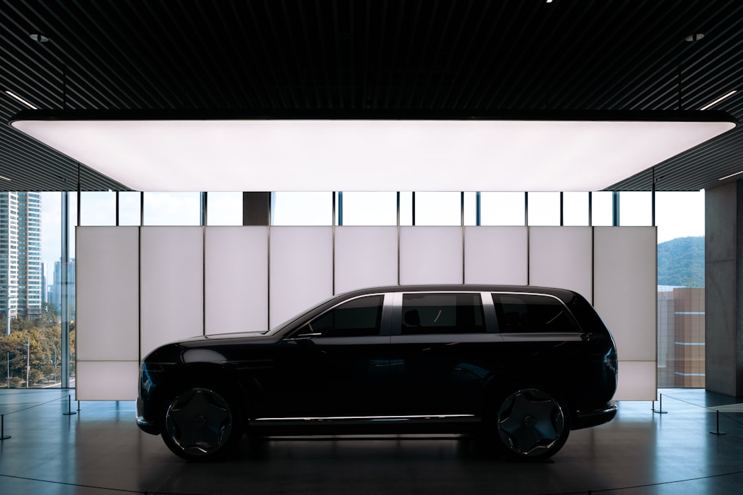 A sleek black car is prominently displayed in a spacious room, exuding a sense of modernity and sophistication.