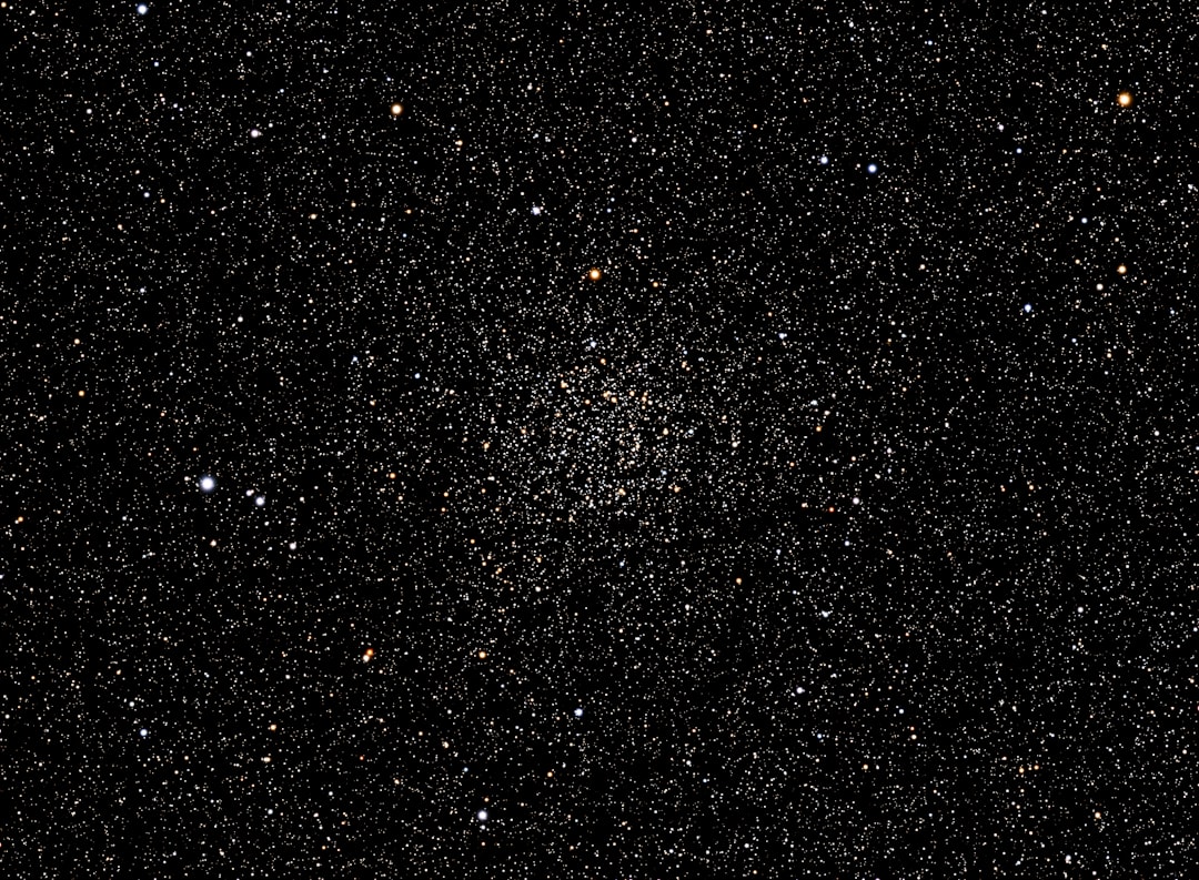 A starry sky with a multitude of small, glowing orbs, likely a celestial body or a group of stars, set against a dark background.