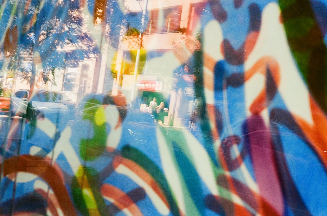 A vibrant mural of a woman's legs, set against a backdrop of a busy street with cars and people in motion.