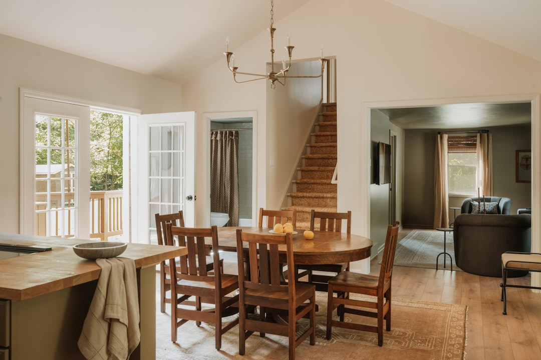 A warm, inviting dining room with a wooden table and chairs, set against a backdrop of a cozy living area.