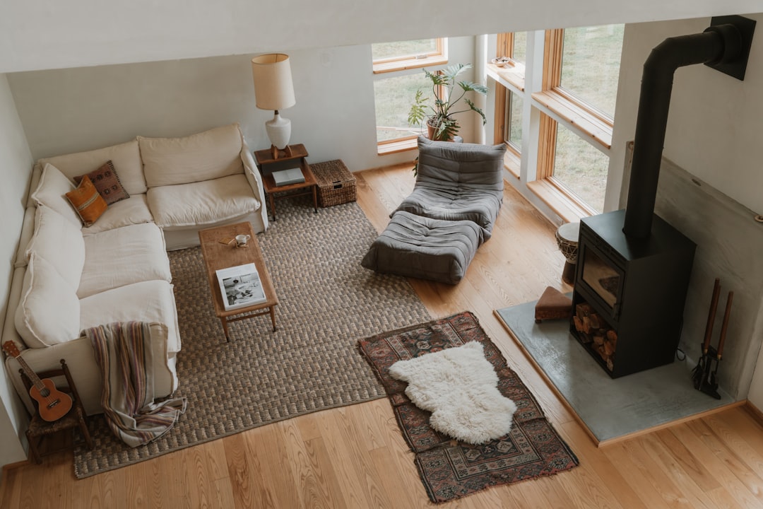 A cozy living room with a white couch, a rug, and a fireplace, exuding warmth and comfort.