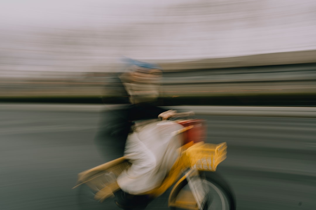 A person in motion on a yellow bike, with blurred features.