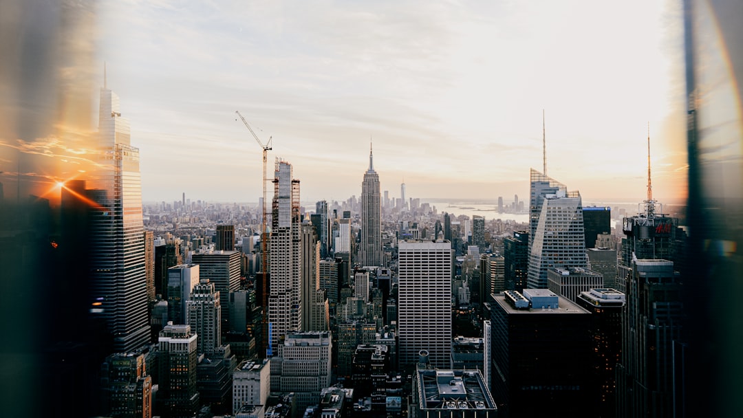 Sunlight filters through towering skyscrapers, casting a warm glow on the concrete jungle.