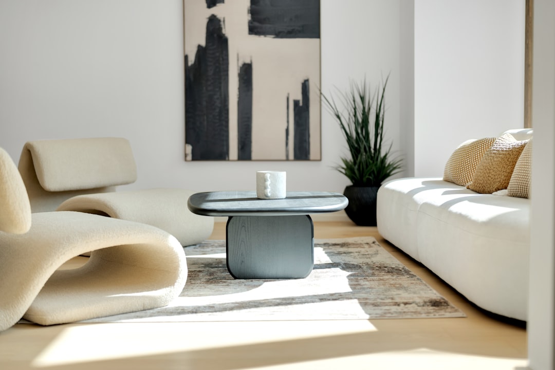 A minimalist living room with a white couch, abstract painting, and natural light pouring in.