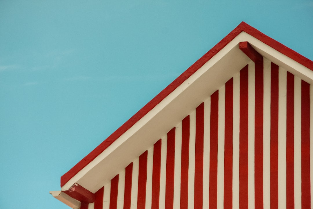 A red and white striped roof against a bright blue sky.