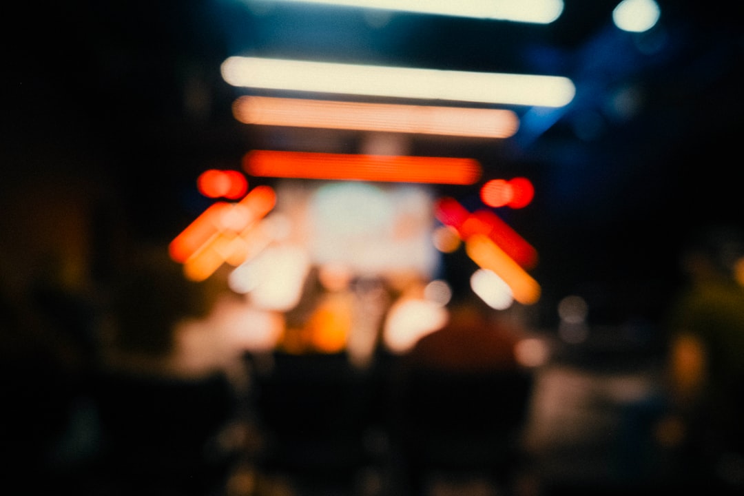 A blurry, dark scene with a row of lights, possibly from a stage or display.