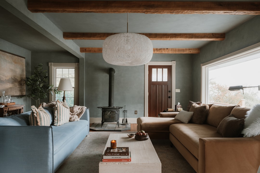 A cozy living room features two sofas, a coffee table, and a wood-burning stove.