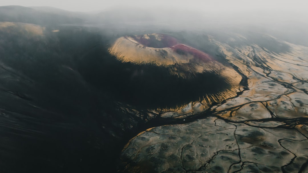 Dark, barren mountains with winding streams of water.