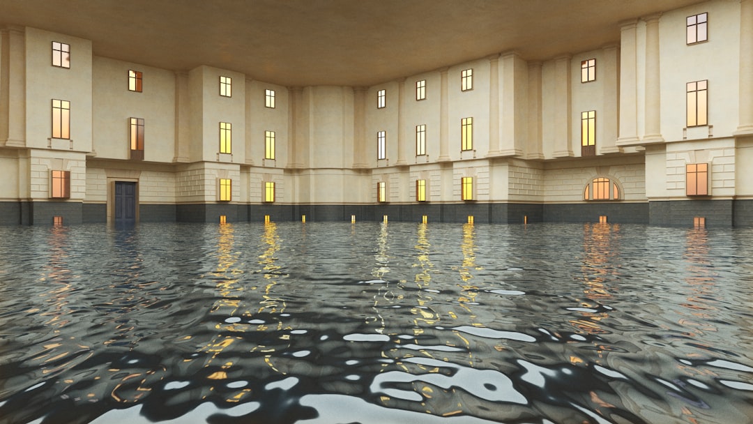 A grand, ornate building with columns and windows stands in a flooded room, surrounded by water.