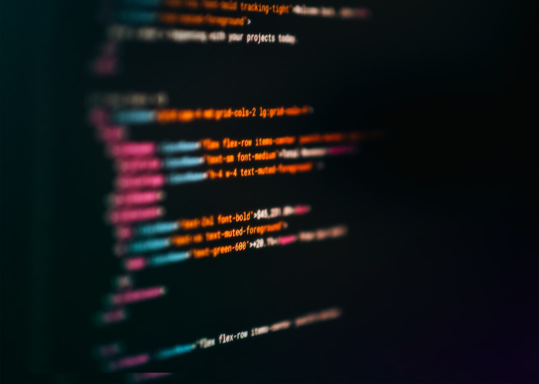 A computer screen displays a vibrant array of colorful code in white, pink, blue, orange, and green, set against a dark background.