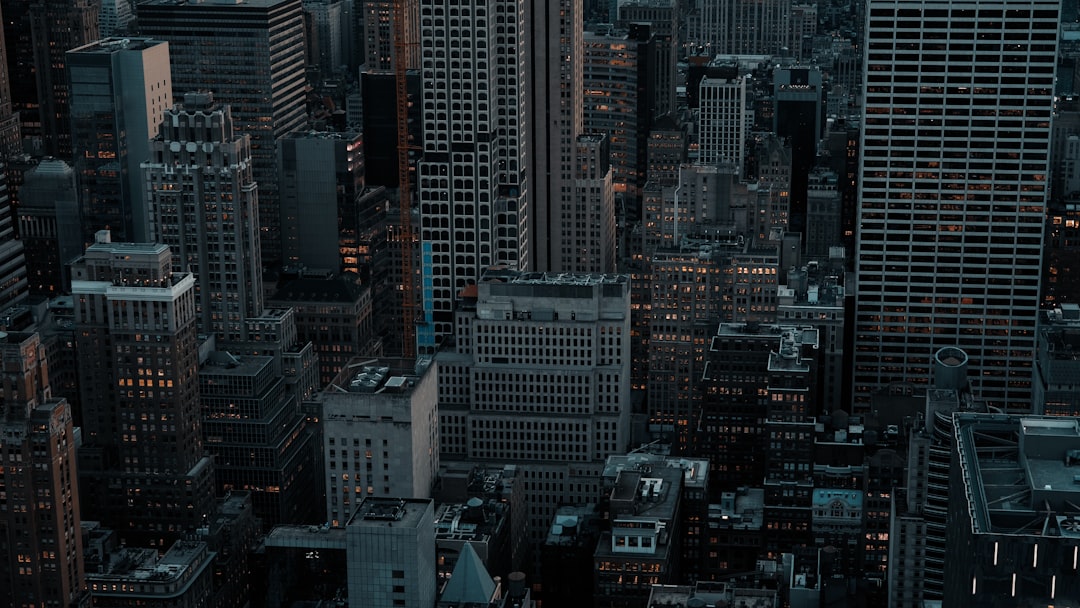 Towering skyscrapers dominate the cityscape, their windows aglow with a warm, golden light.