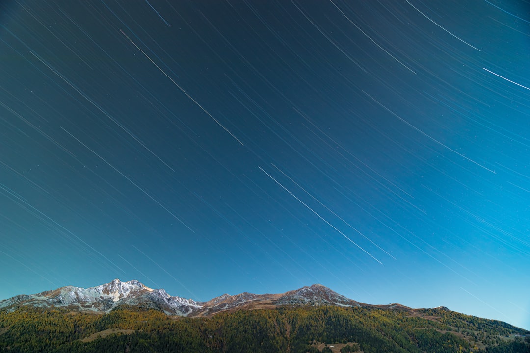 Snow-capped mountains under a starry night sky.