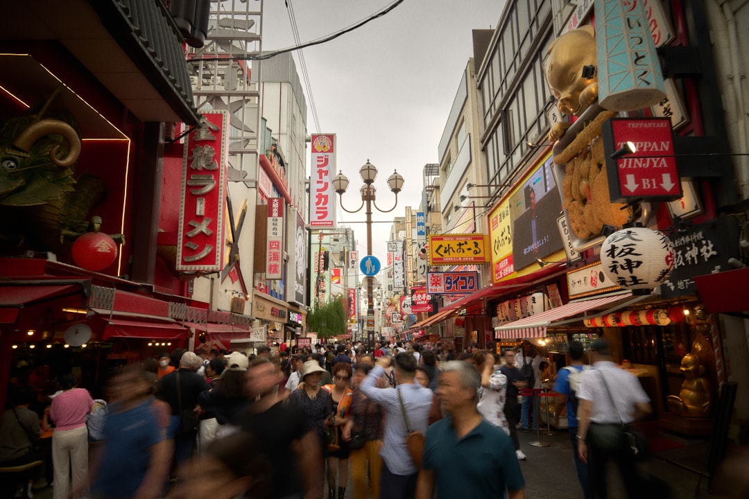 A bustling street scene unfolds, with towering buildings and a sea of people navigating the crowded sidewalk.