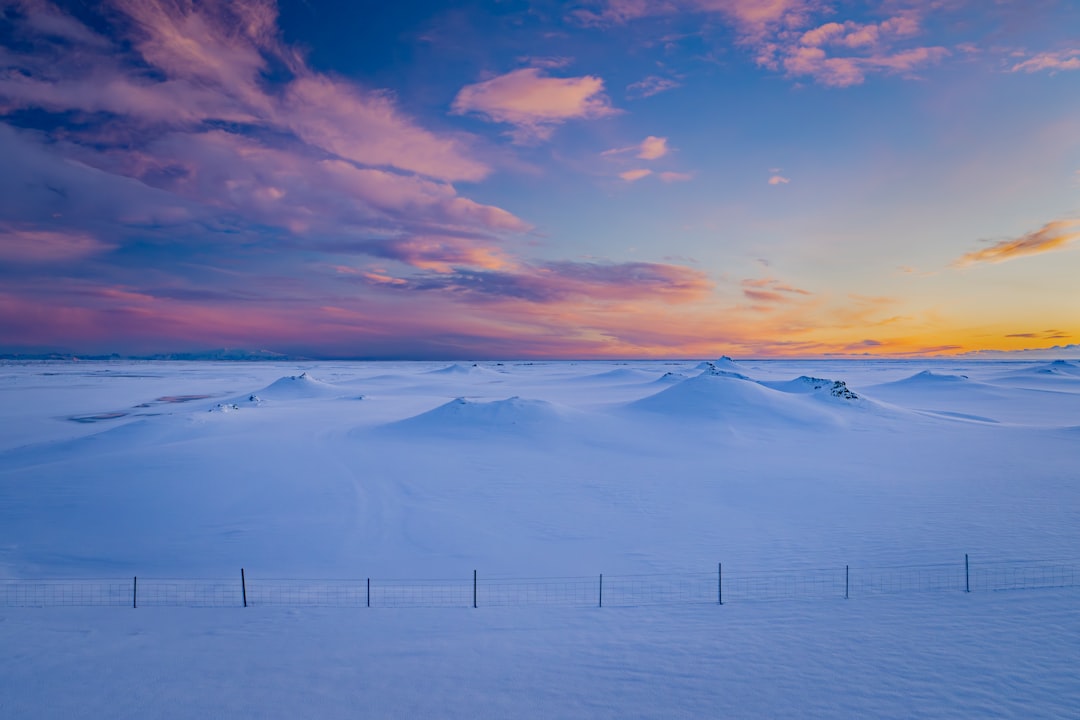 Snow-covered mountains stand tall under a vibrant sunset sky.