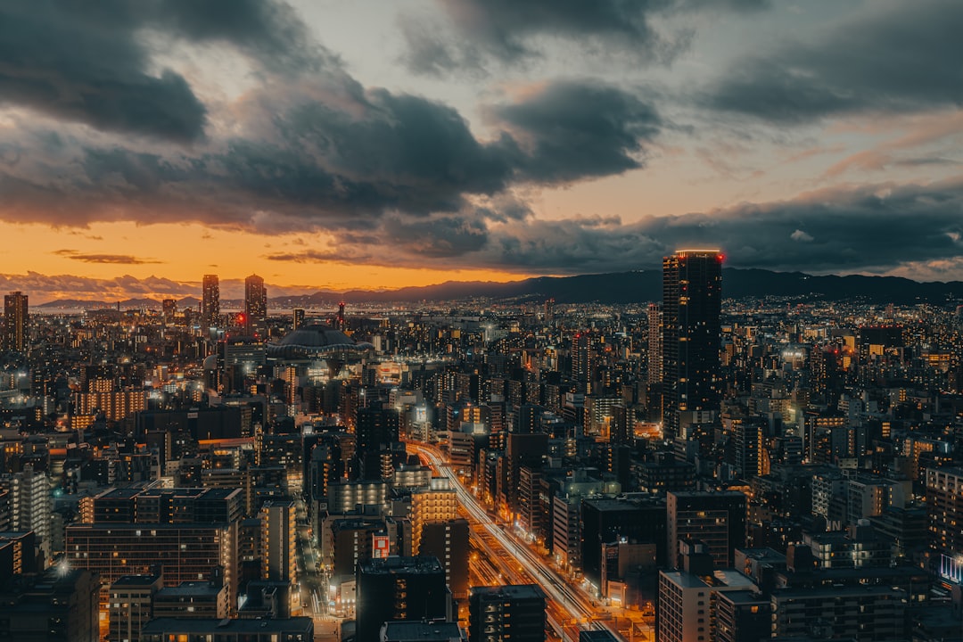 A sprawling cityscape unfolds at dusk, with towering skyscrapers and a tapestry of twinkling lights.
