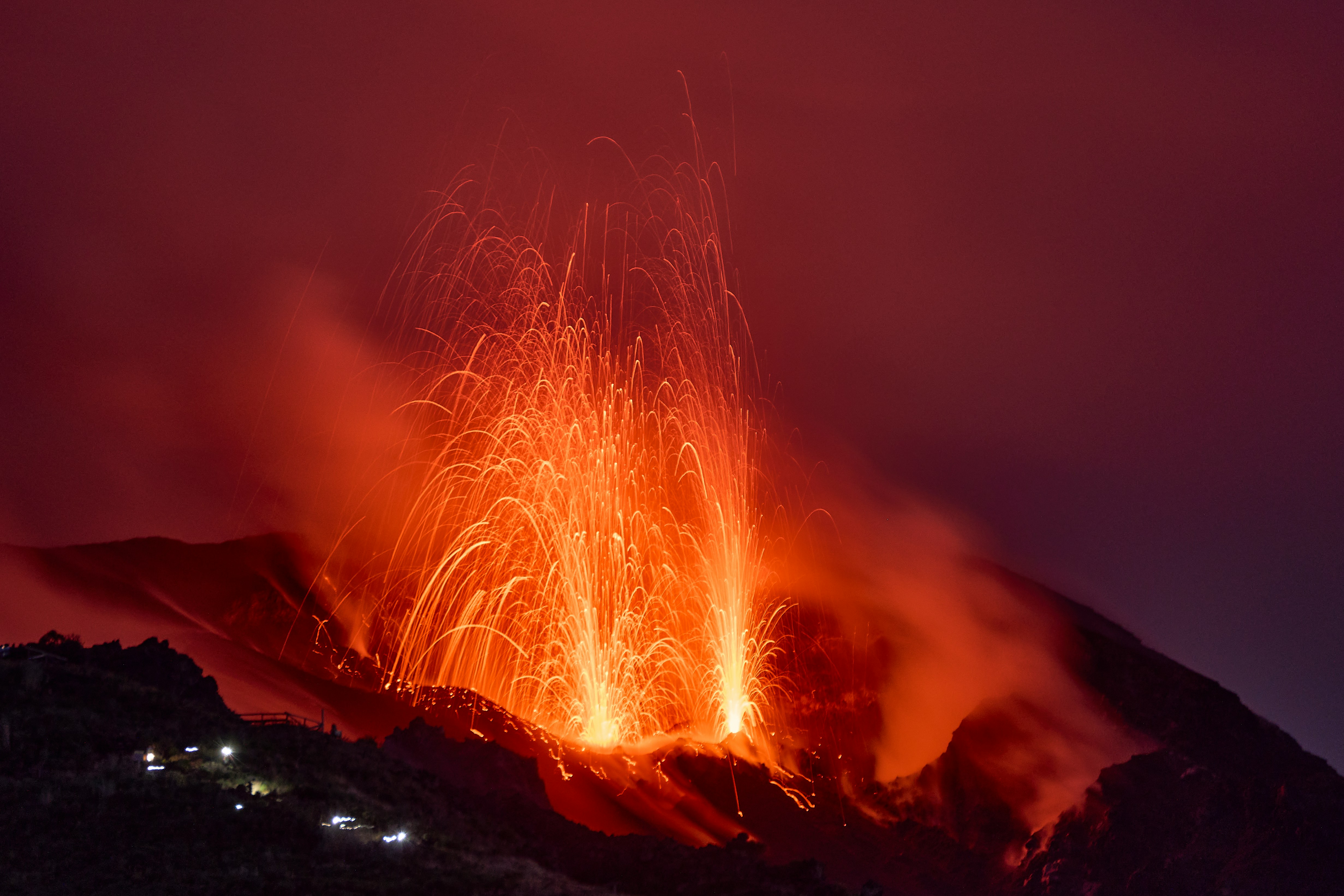 Fiery lava erupts from the earth, casting a fiery glow on the dark surroundings.