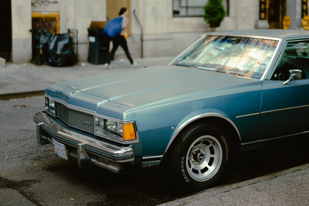 A vintage light blue car is parked on the street.