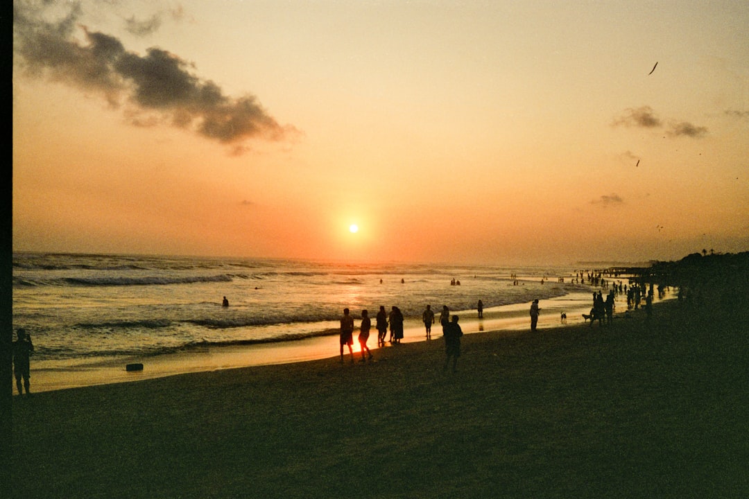 A serene sunset scene unfolds, with the sun's warm glow casting a tranquil ambiance over the beach.