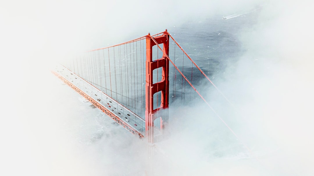 A majestic bridge stands tall, its red towers piercing the fog.