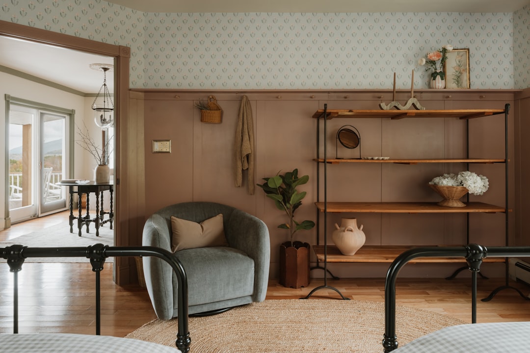 A cozy room with a gray chair, wooden shelves, and a view of a patio or deck.