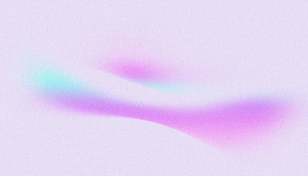 A vibrant streak of pink and green light cuts across a soft, white background.
